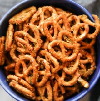 overhead closeup showing seasoned pretzels piled in a bright blue bowl