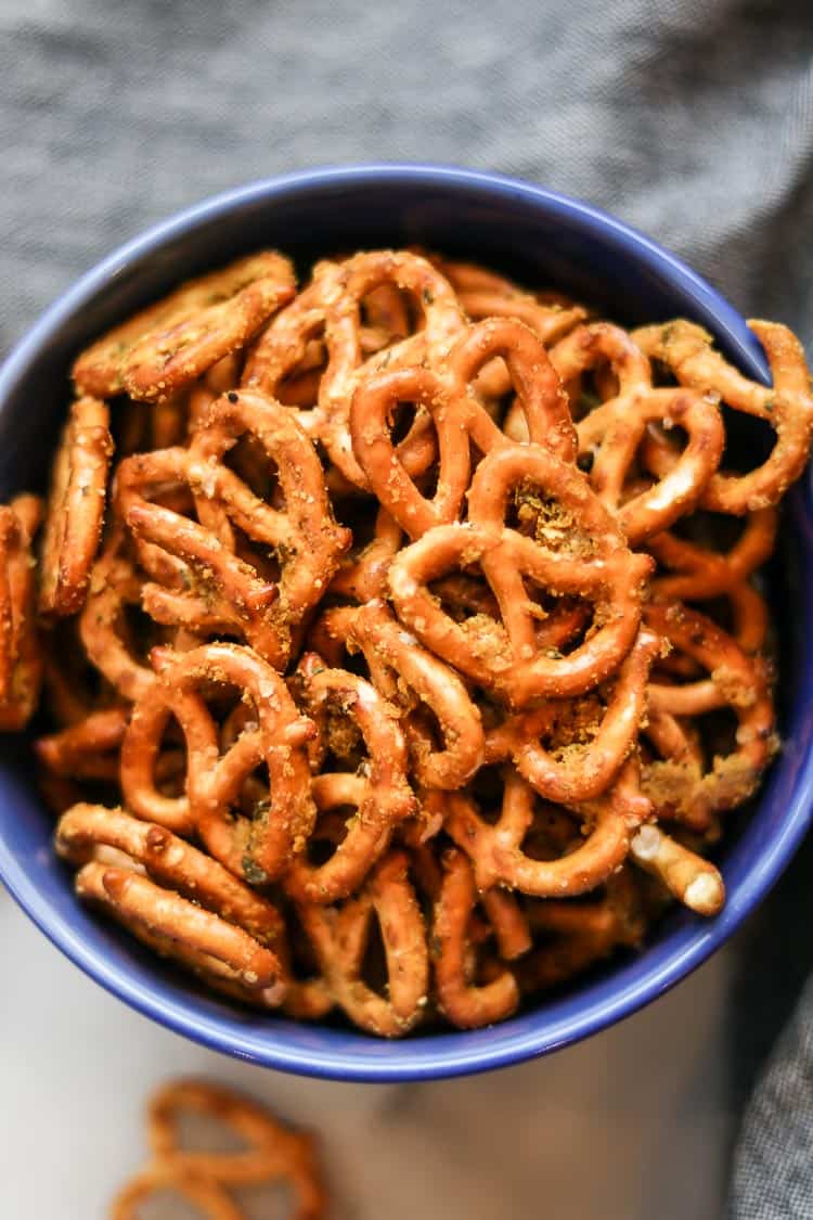 overhead closeup shot of seasoned pretzels filling a bright blue bowl