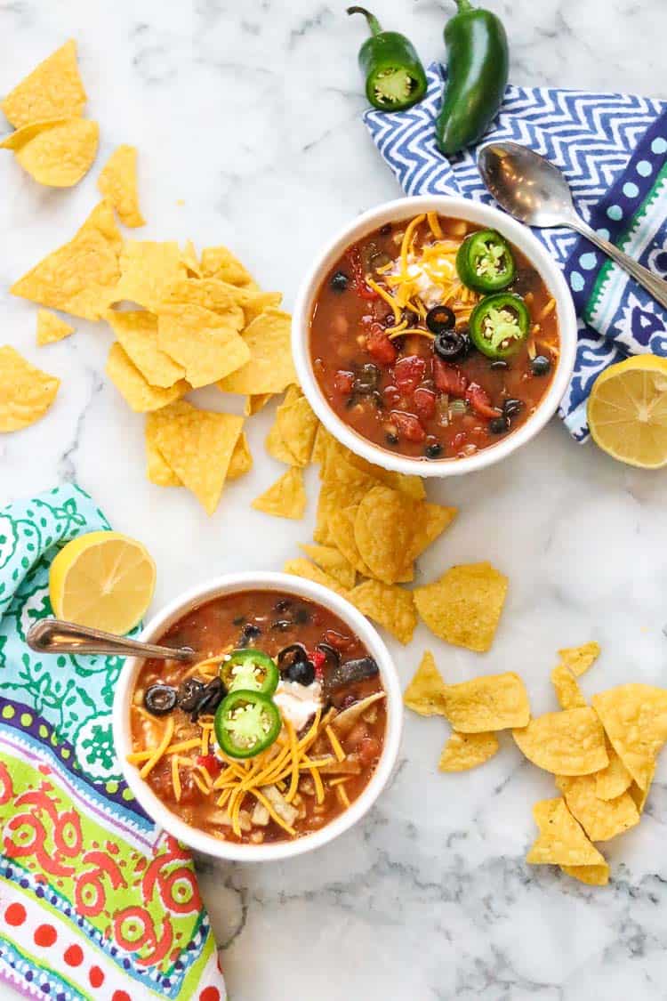 overhead photos of two bowl of vegan taco soup in white bowls with chips nearby