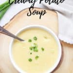 overhead shot of vegan potato soup on a wooden slab with text overlay for pinterest