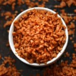 overhead closeup shot of vegan bacon bits in a white finger bowl setting on a black baking tray