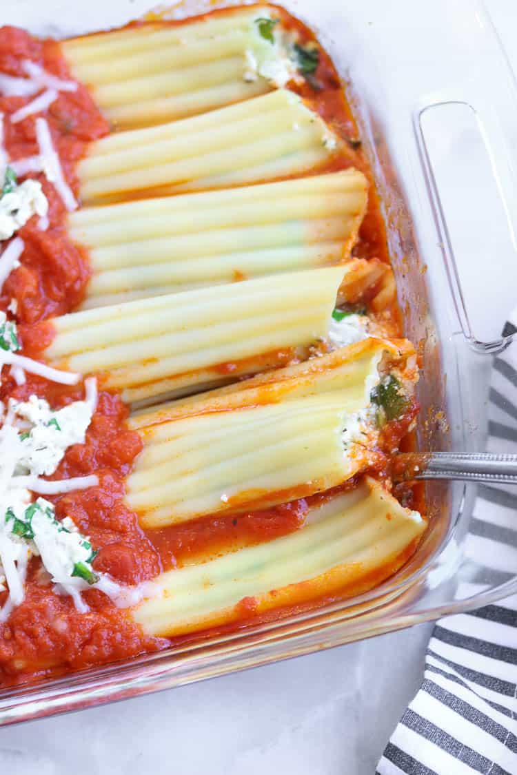 Closeup view of pan of vegan manicotti with tofu ricotta filling.