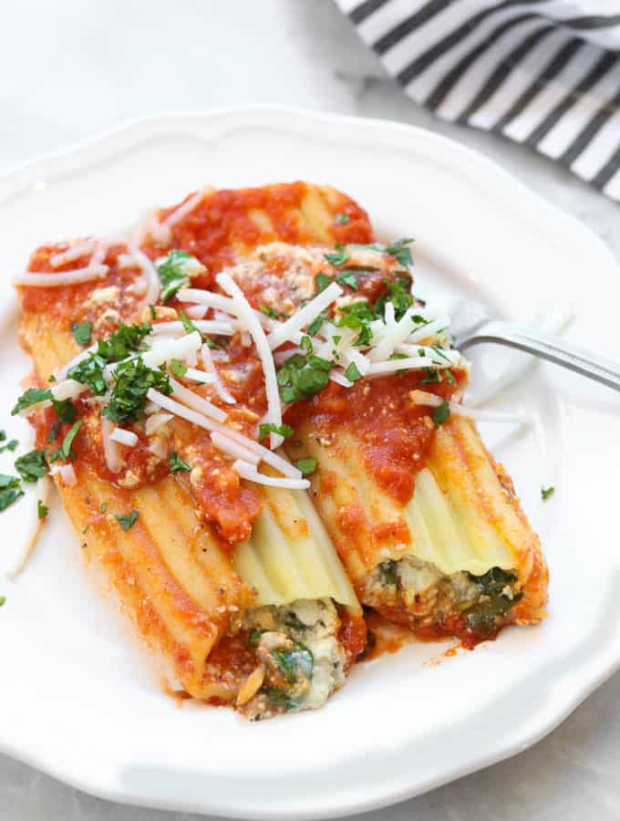 side overhead photo of two vegan manicotti shells on a white plate