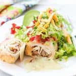 side overhead shot of decked out vegan chimichanga on a white plate with text overlay for pinterest