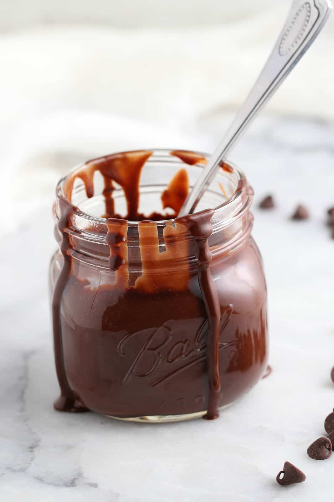closeup side view of pint jar with chocolate sauce dripping down the sides