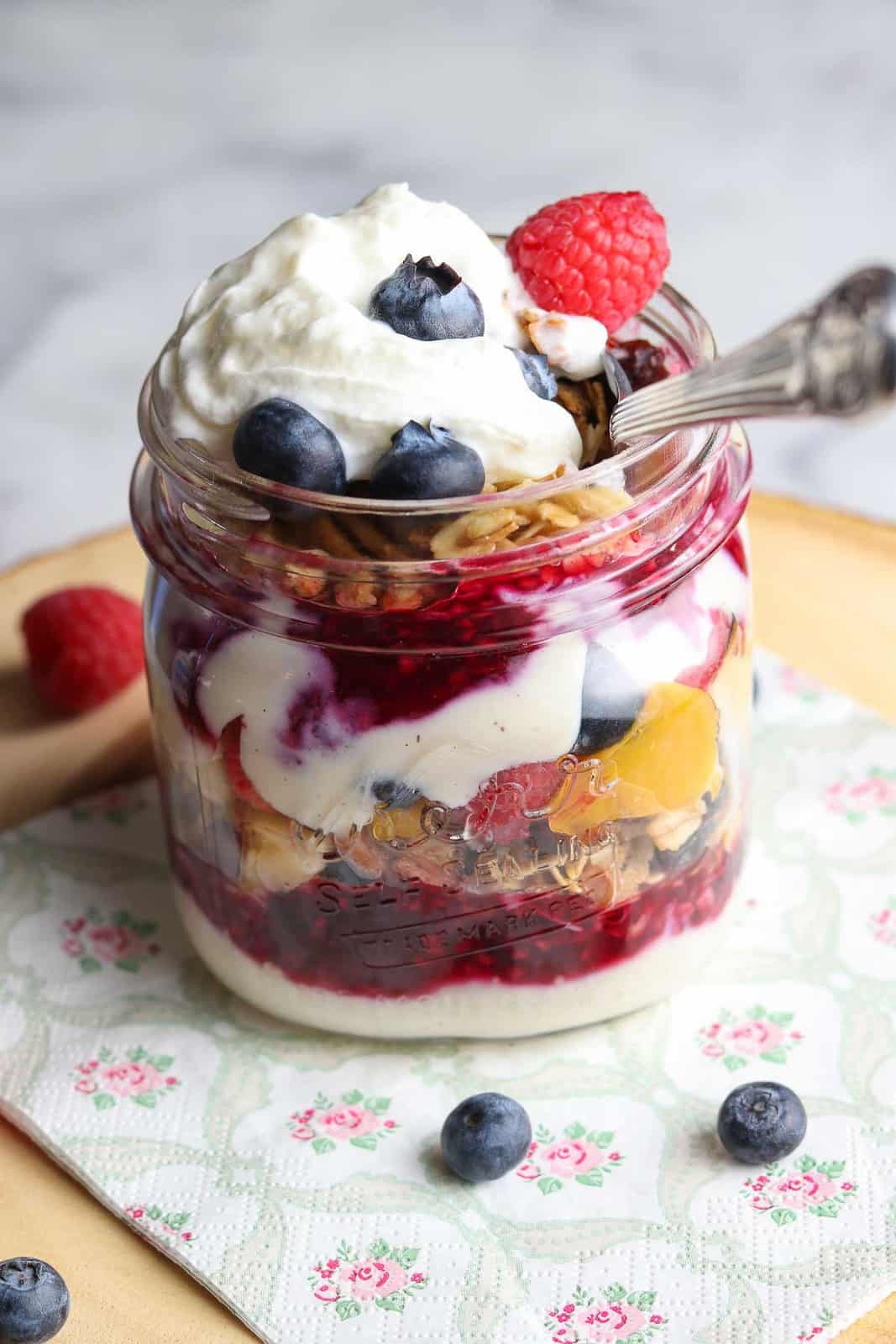 side overhead photo showing silver spoon in whipped cream topping layer of the parfait