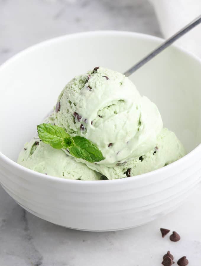 side overhead shot showing scoops of mint chocolate chip ice cream in a white bowl