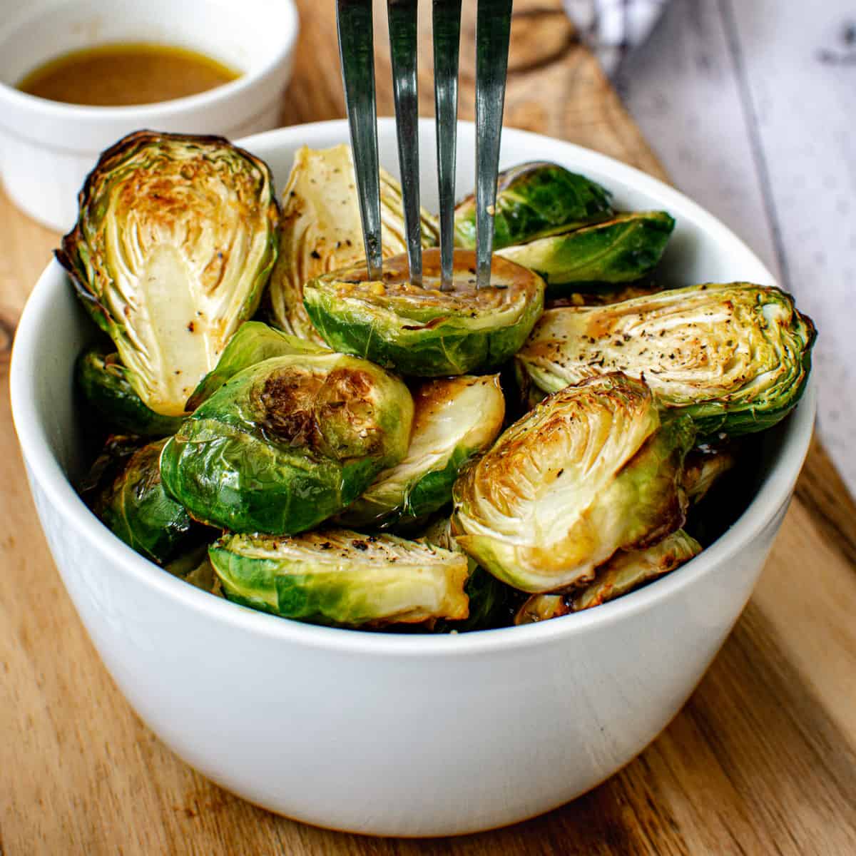 bowl of roasted brussels sprouts with a fork grabbing a brussels sprout