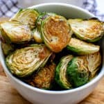 bowl of roasted brussels sprouts drizzled with balsamic maple dressing