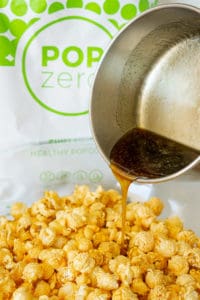 pouring maple caramel into a bowl of popcorn