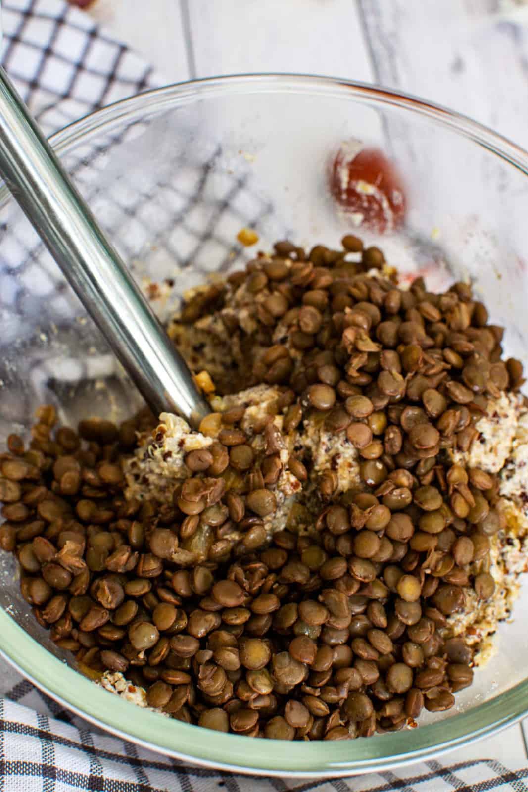 using an immersion blender to puree cooked green lentils