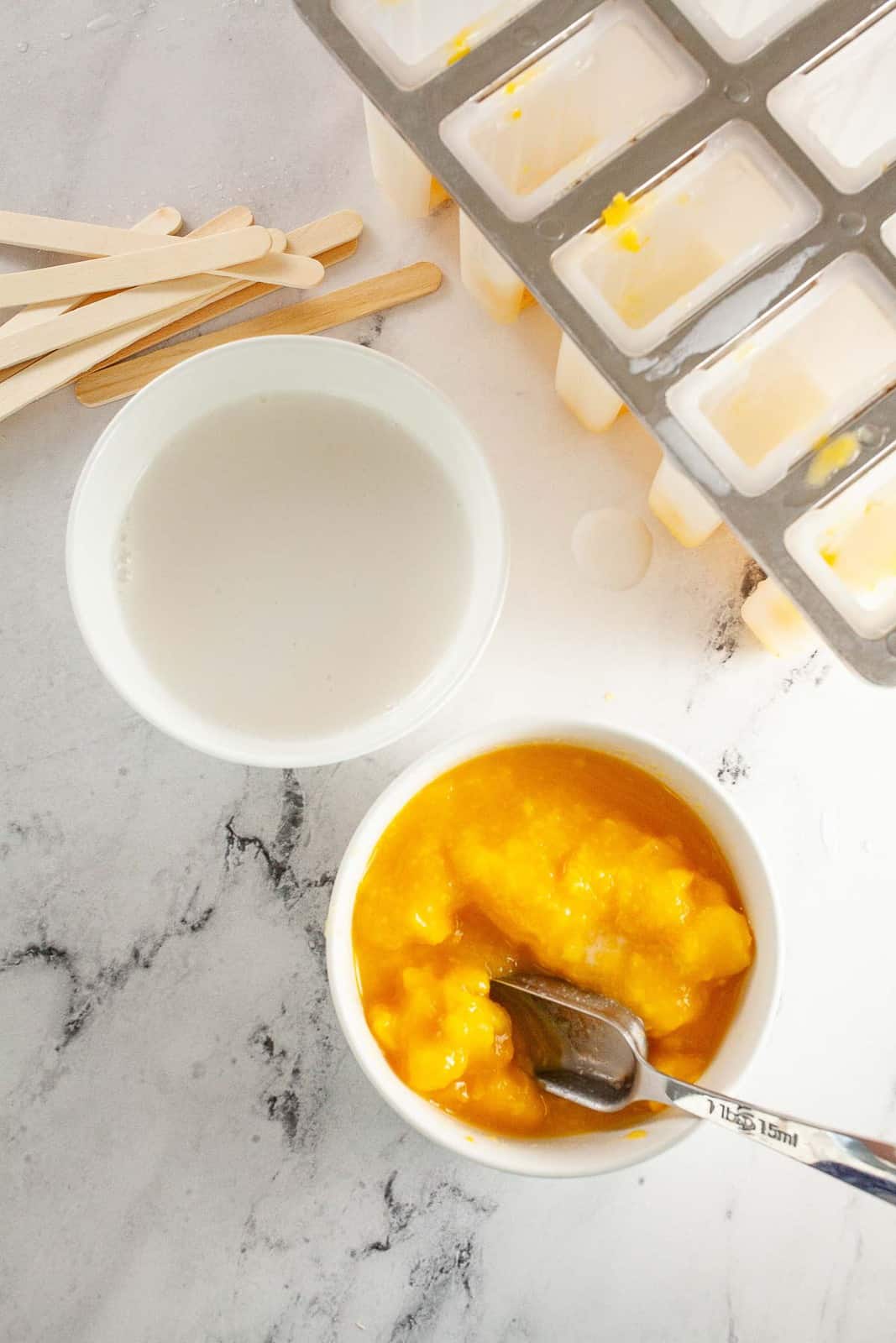 Mango pulp and coconut milk in bowls.