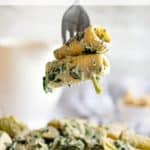 Pinnable image of vegan spinach artichoke Alfredo pasta.