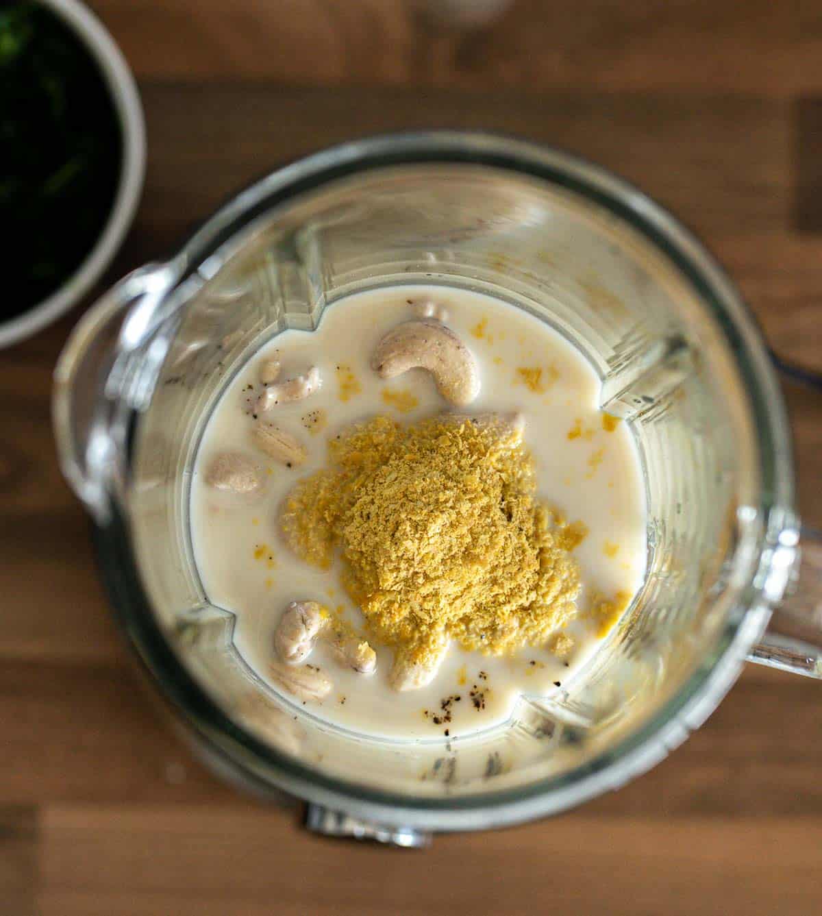 Ingredients to make vegan creamy cashew sauce in a blender.