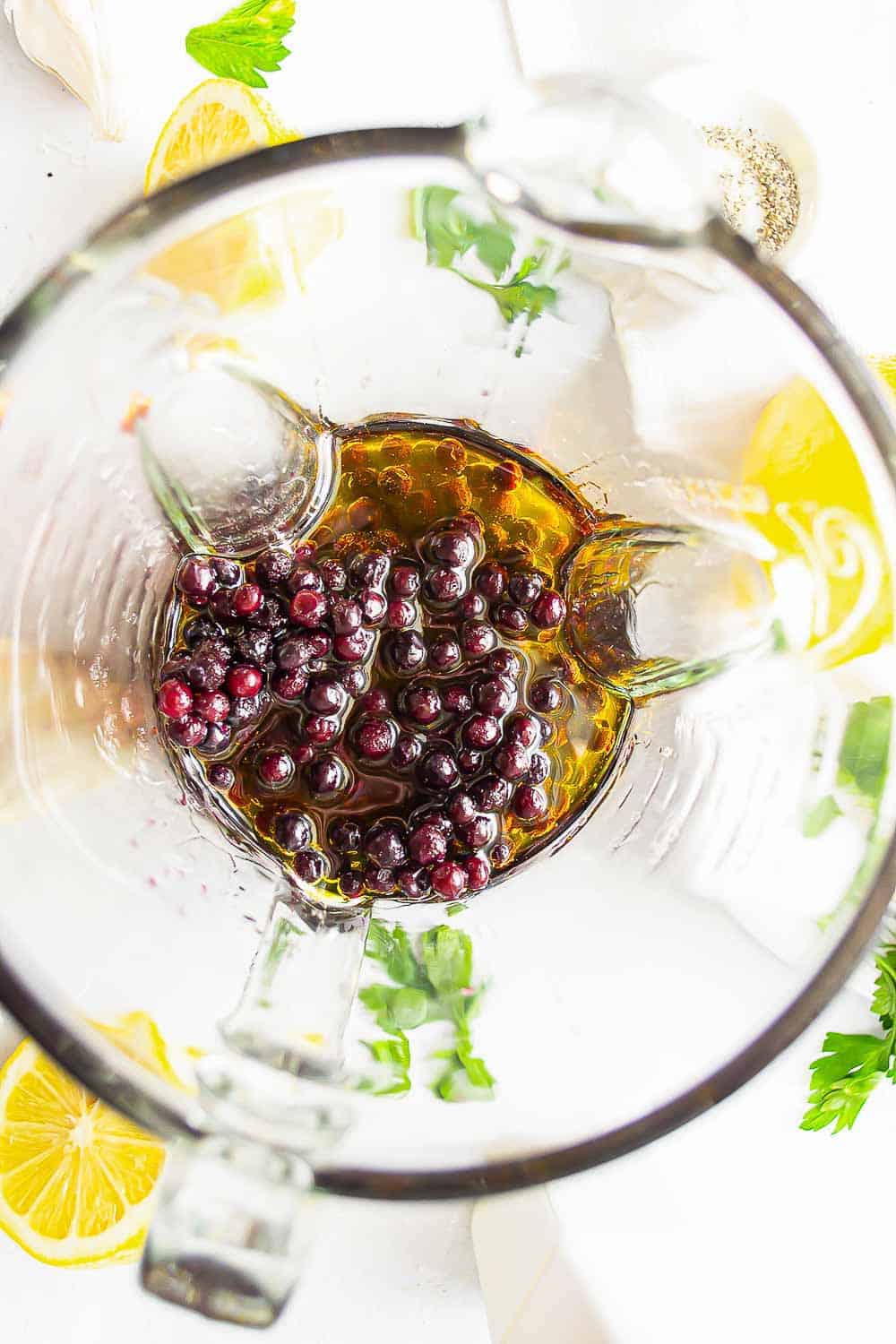 Frozen blueberries and other dressing ingredients in a blender.