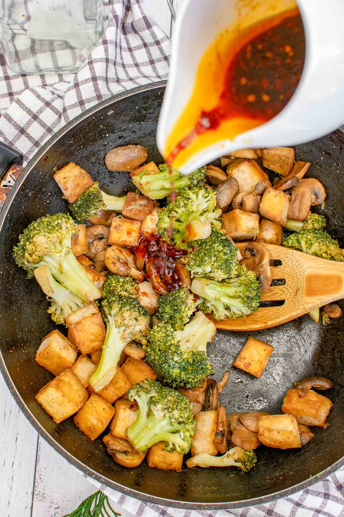 Adding soy balsamic stir fry sauce to vegetables.