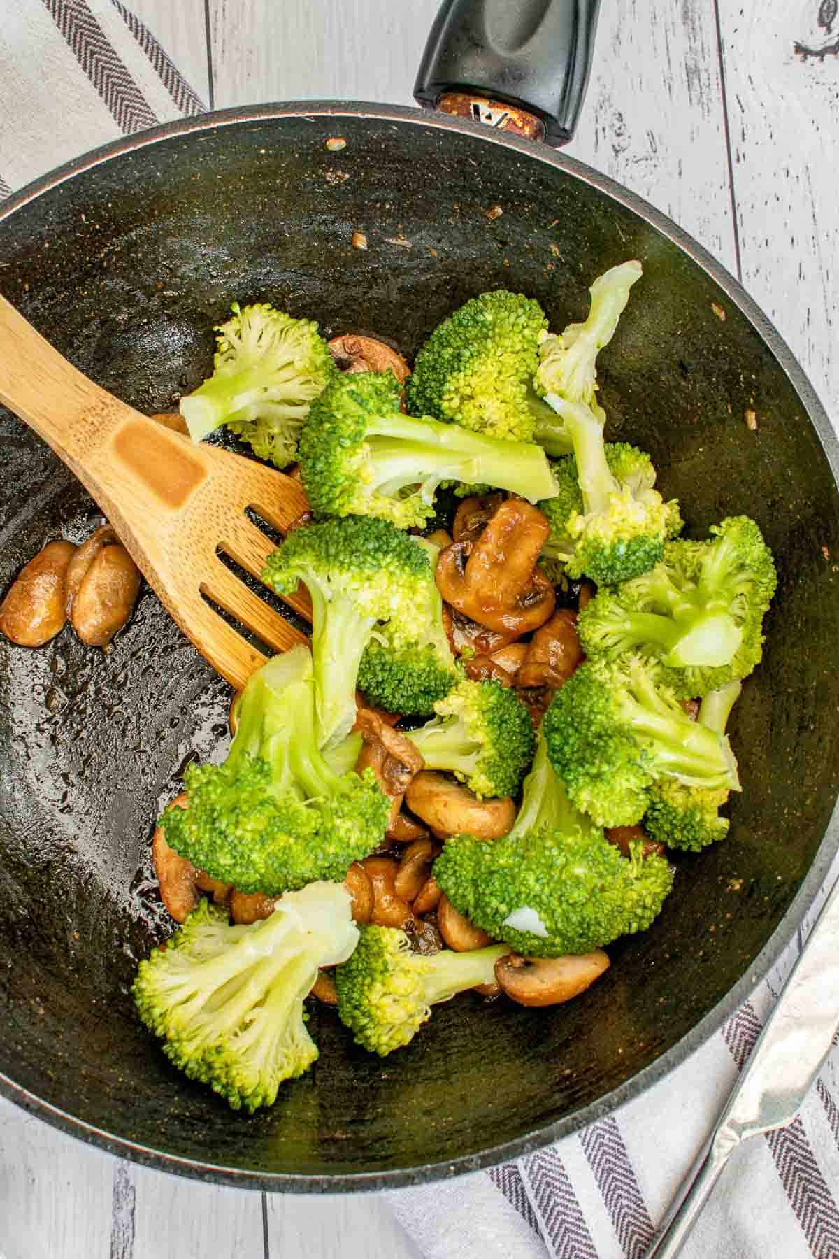 Broccoli and mushroom stir fry in a wok.