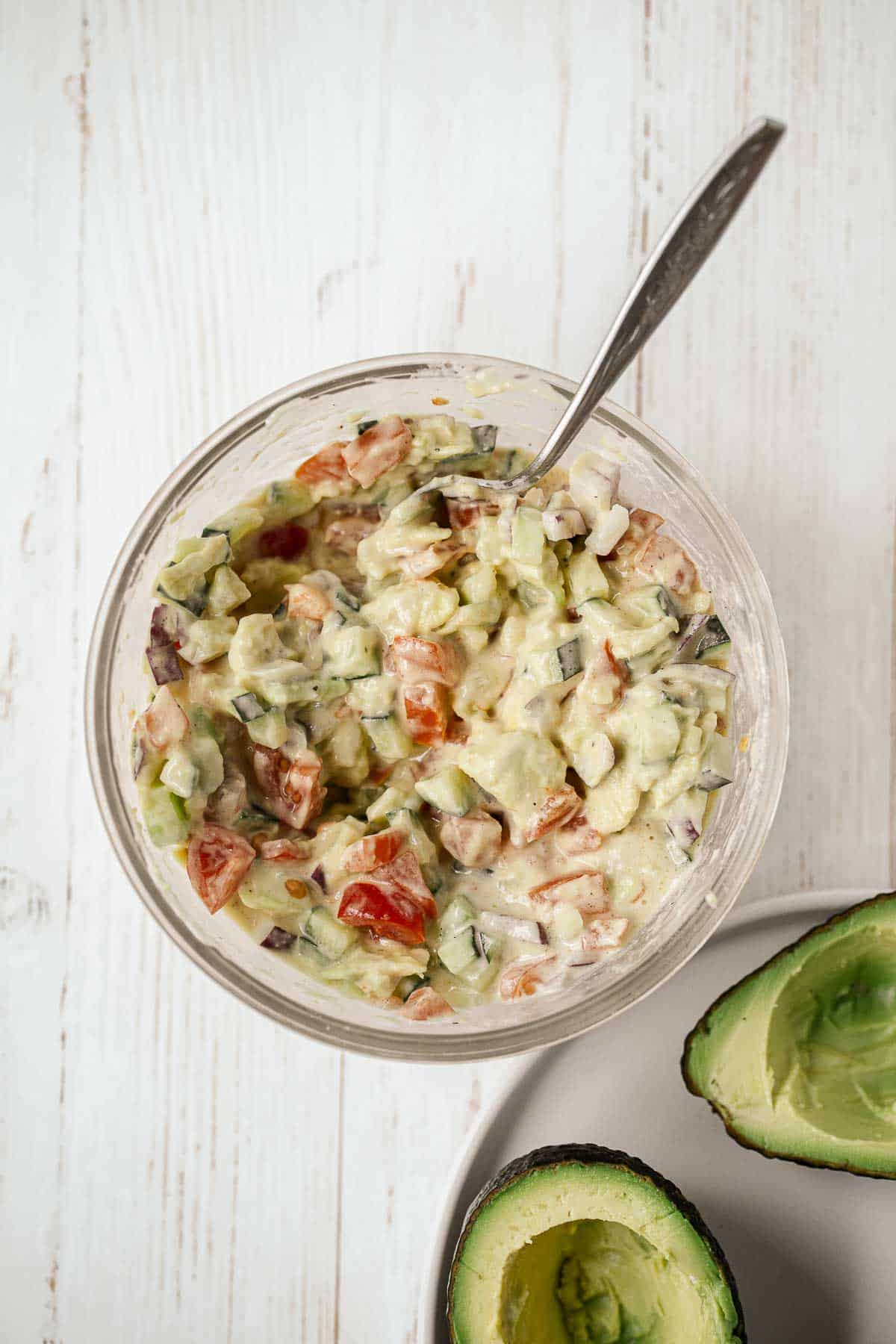 Creamy cucumber tomato avocado salad in a bowl.