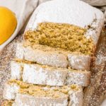 Close up of lemon loaf sliced on a cutting board.