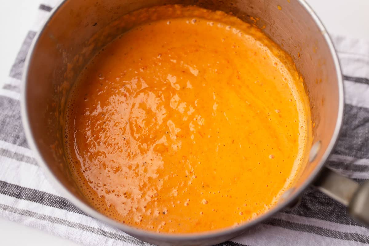 Creamy roasted red pepper sauce blended in a pot.