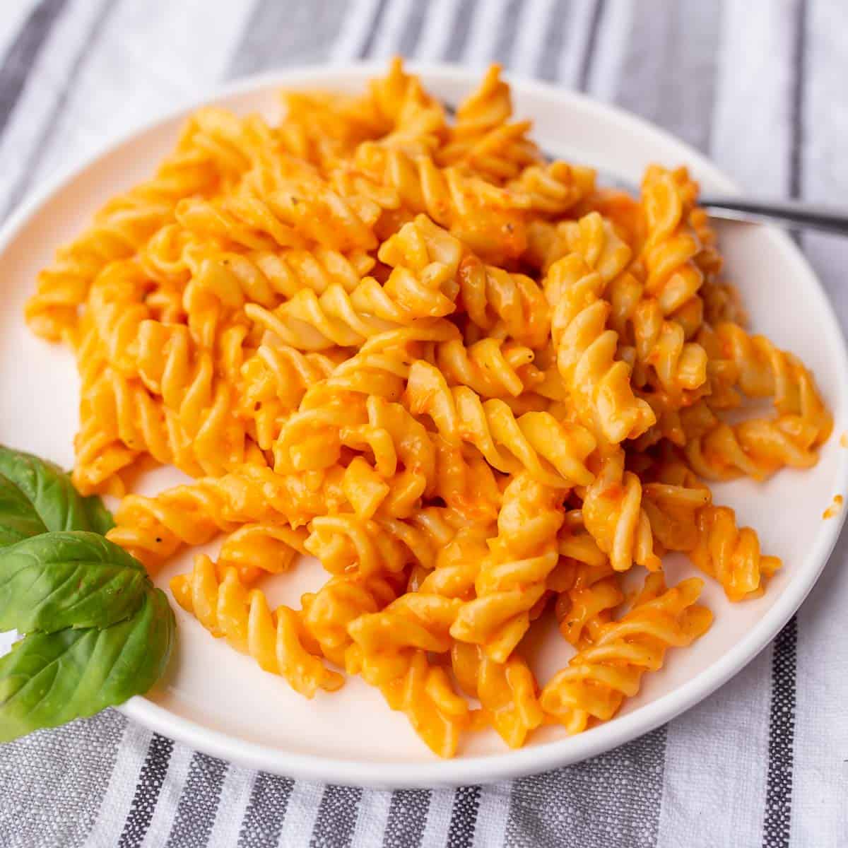 Plate of pasta with creamy roasted red pepper sauce.