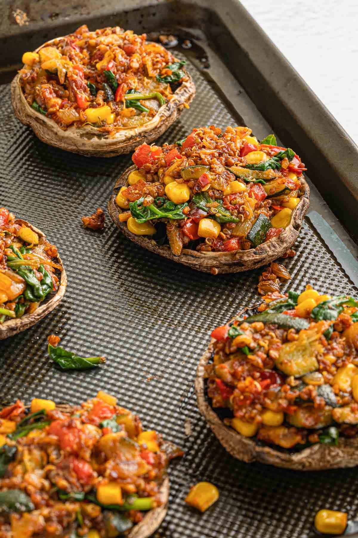 Vegan stuffed portobello mushrooms on a baking sheet.