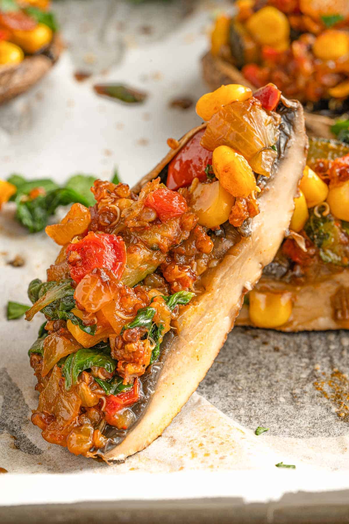 Portobello mushroom stuffed with vegetables sliced in half.