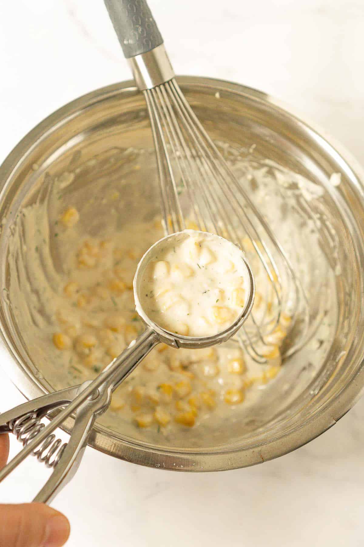 Corn fritter batter in an ice cream scoop