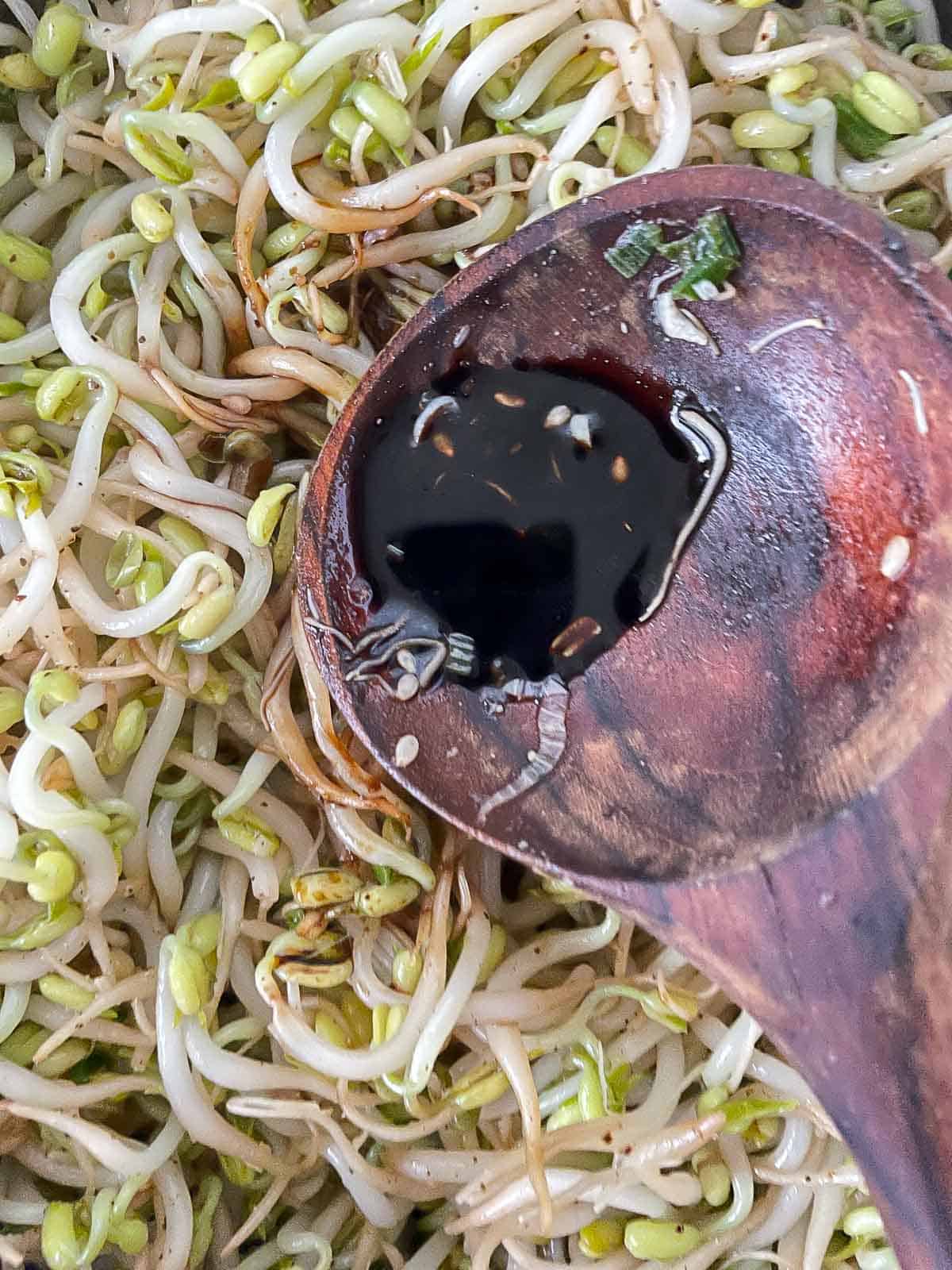 Adding soy sauce to stir fried bean sprouts