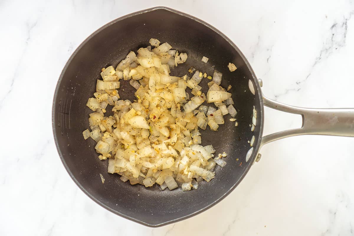 Diced onion and garlic sautéing in a soup pot.