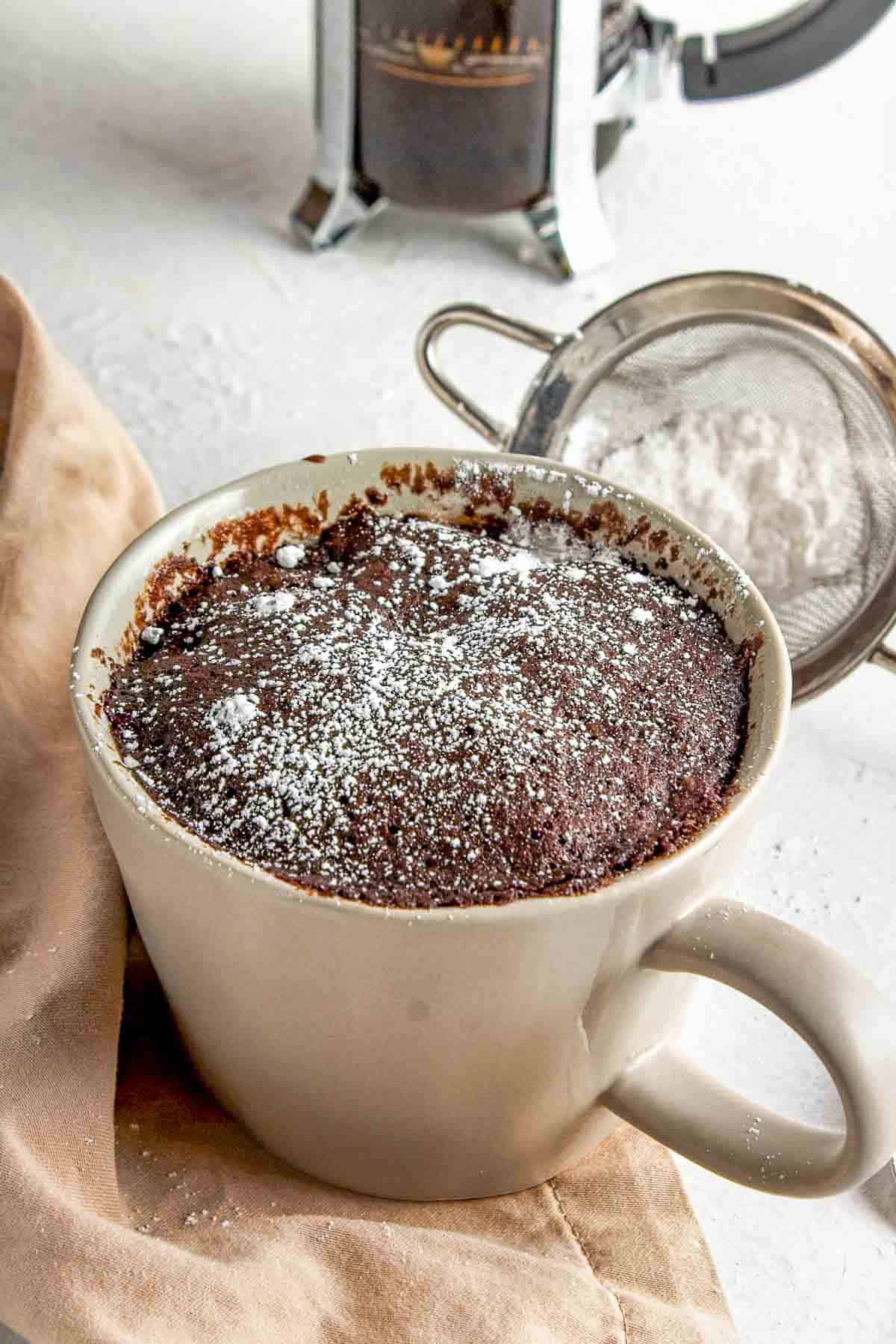 Vegan mocha mug cake with powdered sugar on top