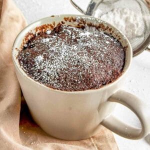 Vegan mocha mug cake with powdered sugar sprinkled on top