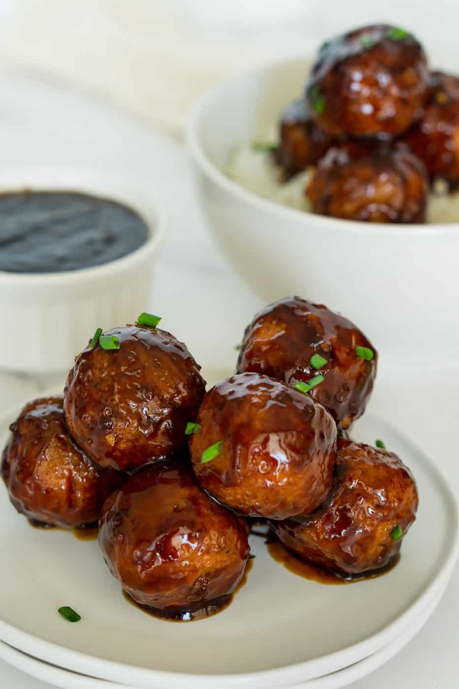 Stack of vegan meatballs with garlic ginger glaze on a plate.