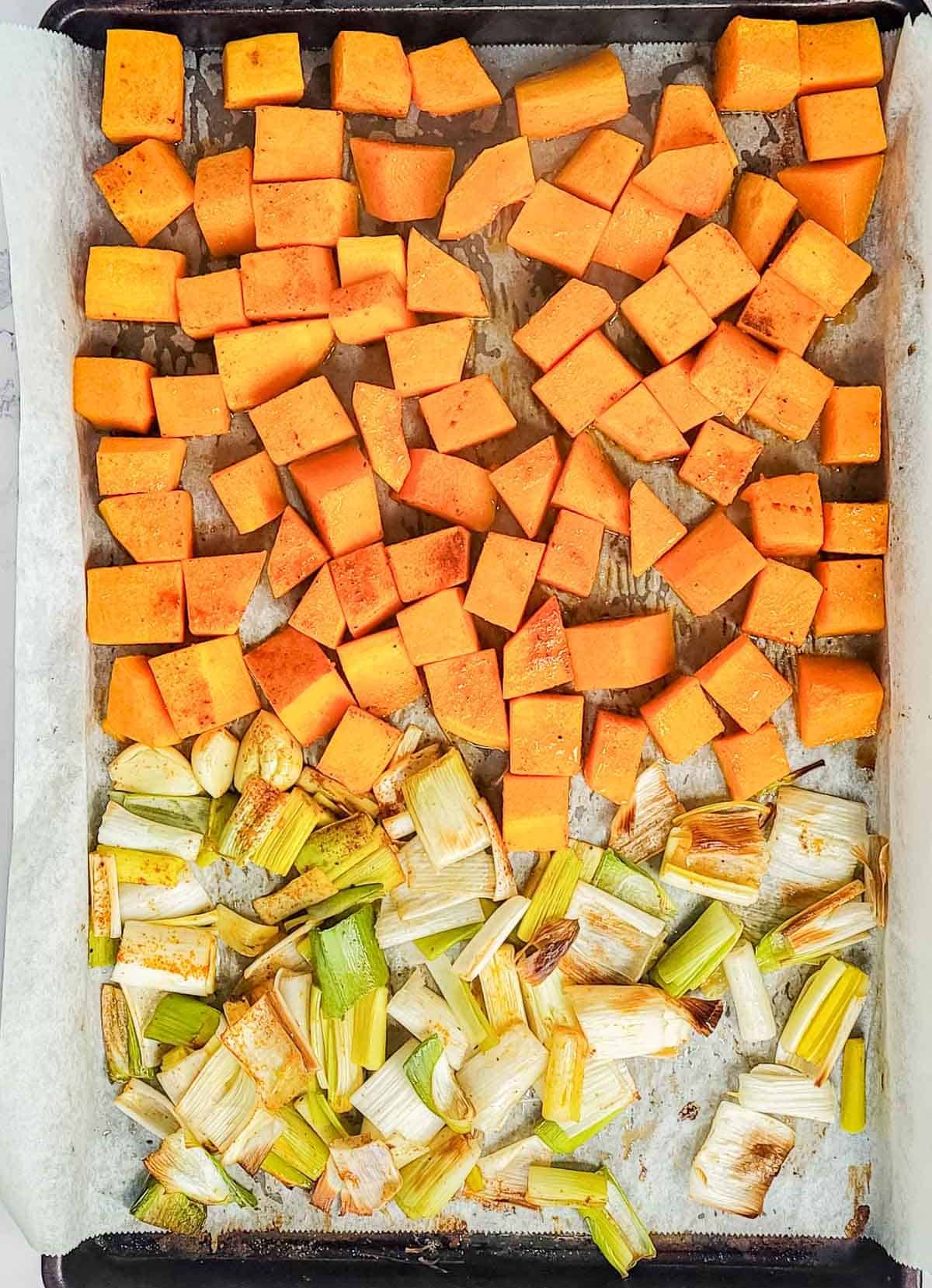 Roasted butternut squash and leeks on a baking sheet