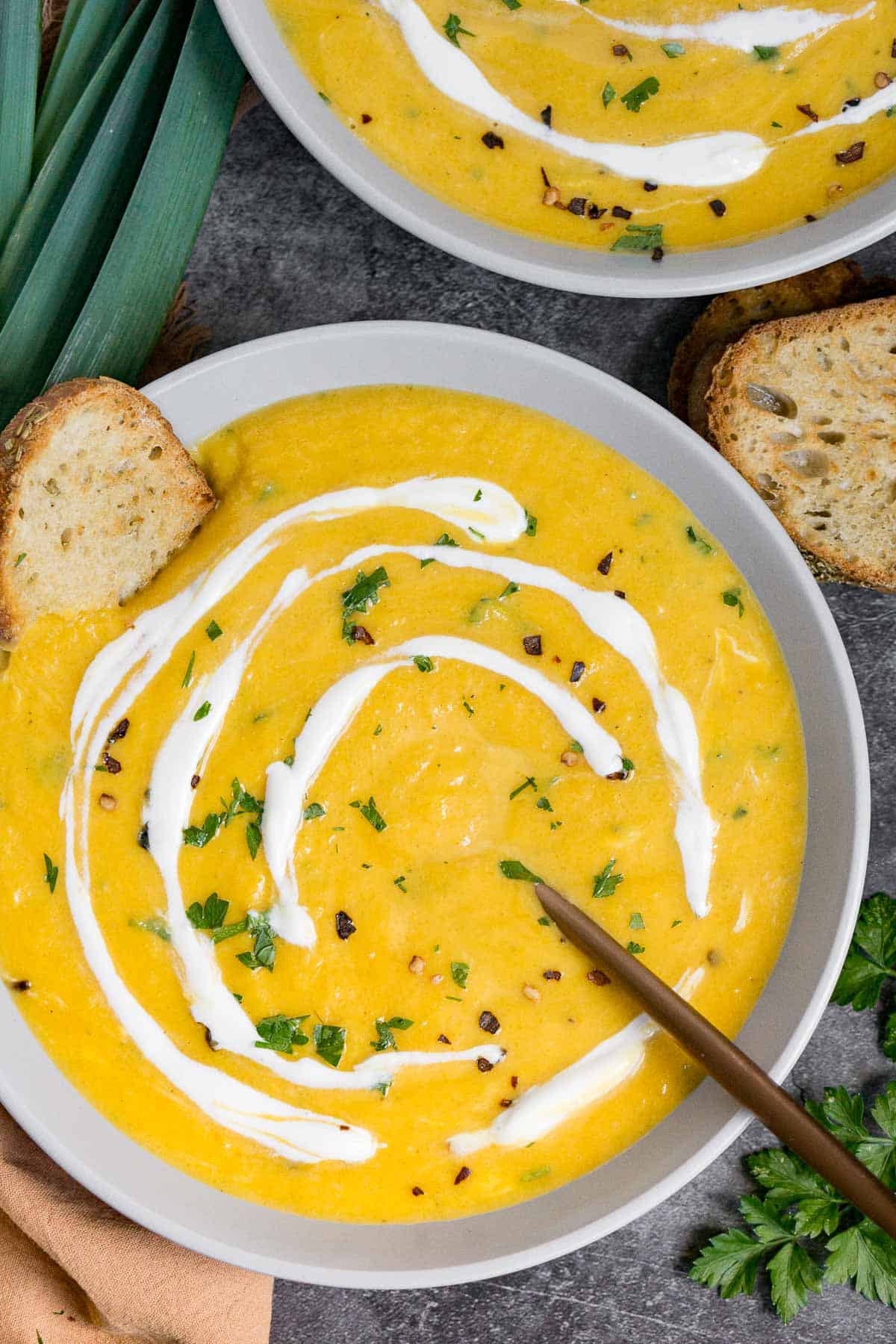 Bowl of vegan butternut squash leek soup with a coconut milk drizzle