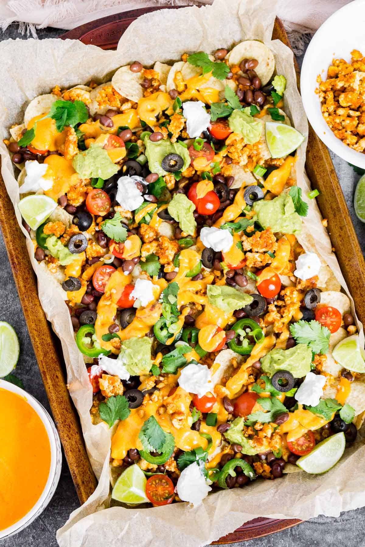 Platter of loaded vegan nachos with vegan nacho cheese
