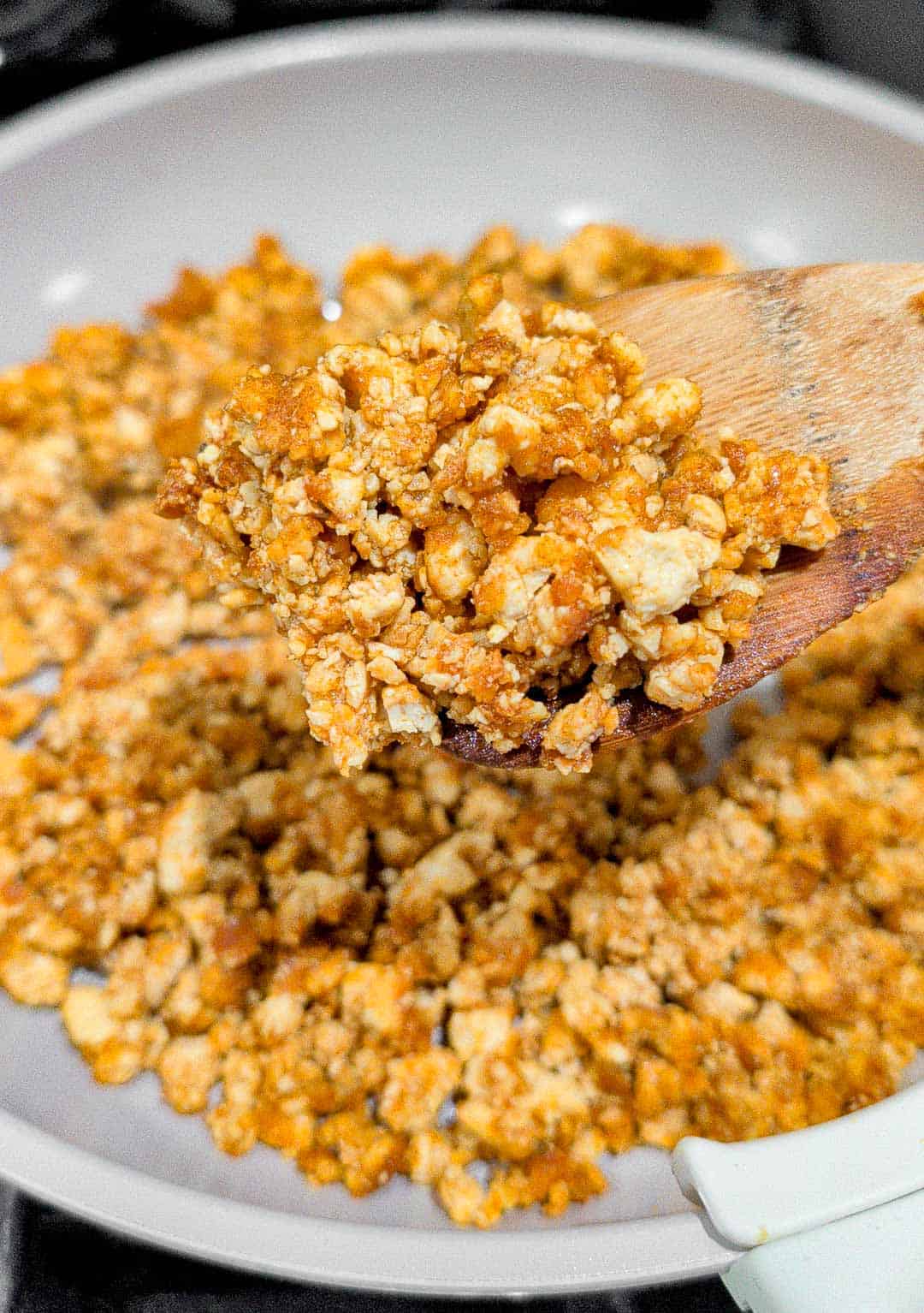 Tofu crumbles on a spatula to show texture